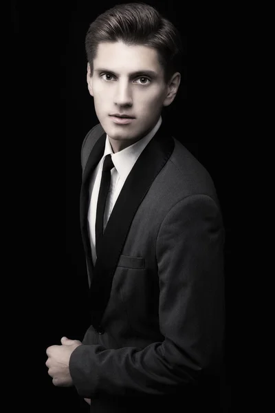 Young attractive macho in suit on black background — Stock Photo, Image
