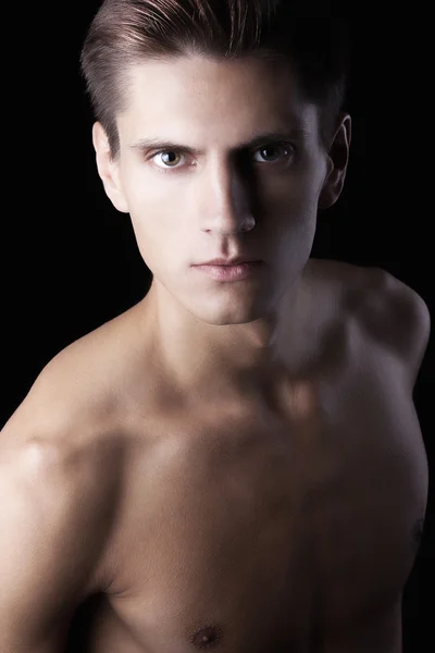 stock image Young attractive macho with beautiful body on black background