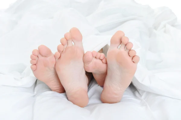 Close-up dos pés de um casal na cama — Fotografia de Stock