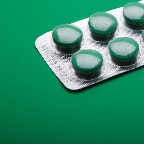 Makro pilulek izolovaných na zeleném pozadí — Stock fotografie