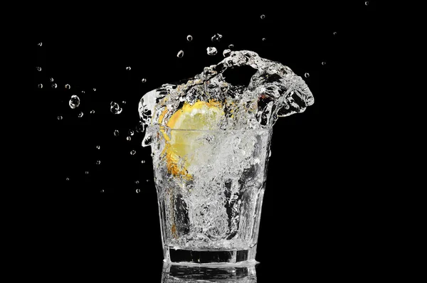 Spruzzare in un bicchiere con limone e ghiaccio su fondo nero — Foto Stock