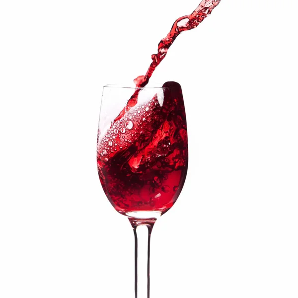 Rotwein in ein Glas spritzen. Nahaufnahme. isoliert auf weißem Hintergrund — Stockfoto