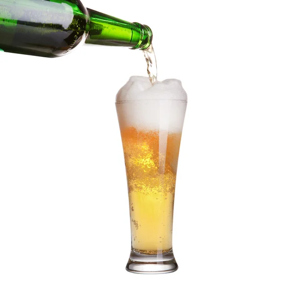 Bier dat uit de fles stroomt in glas dat op wit is geïsoleerd — Stockfoto