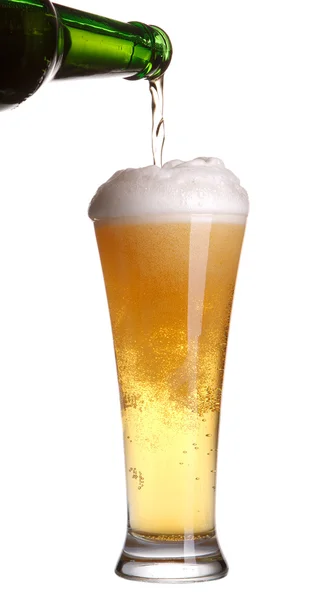 Cerveja que despeja da garrafa no vidro isolado no branco — Fotografia de Stock