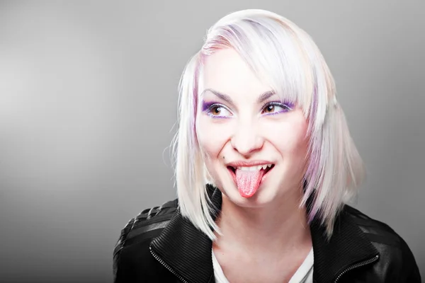 Adolescente loira mostrando língua, isolada em gradiente cinza — Fotografia de Stock