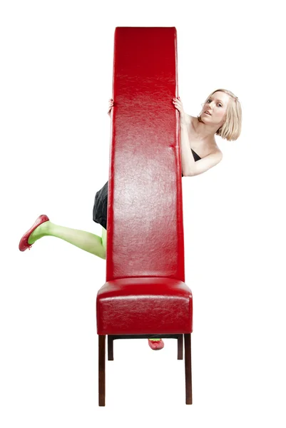 Junge Frau im Abendkleid sitzt auf einem roten Stuhl — Stockfoto