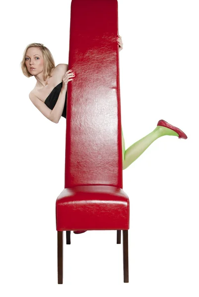Jovem mulher em vestido de noite sentado em uma cadeira vermelha — Fotografia de Stock