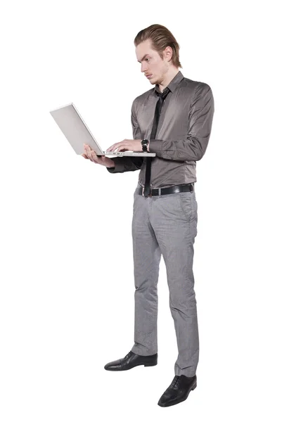 Een jonge man staat met een computer. — Stockfoto