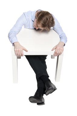 jonge zakenman, kantoor werknemer of student slapen aan grappige kleine tafel. Studio foto van slapen man. geïsoleerd.