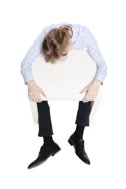 jonge zakenman, kantoor werknemer of student slapen aan grappige kleine tafel. Studio foto van slapen man. geïsoleerd.