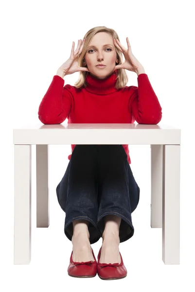 Young woman sitting at funny small desk — Stock Photo, Image