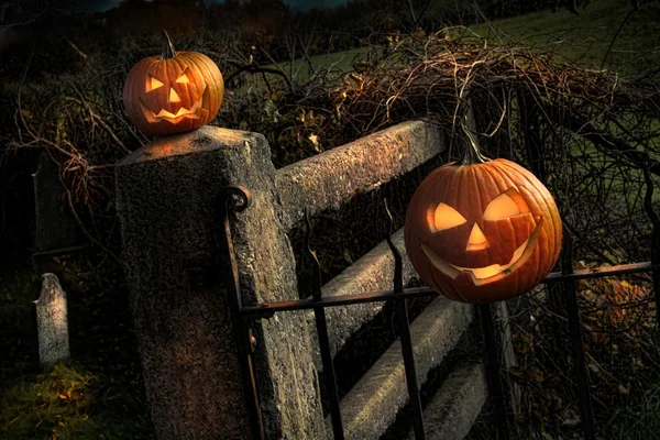 Duas abóboras de Halloween sentadas na cerca — Fotografia de Stock