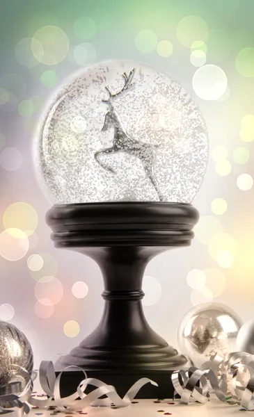 Снігова куля з прикрасами на кольоровому фоні — стокове фото