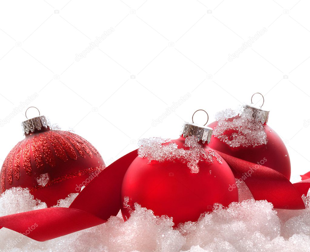 Red Christmas balls and ribbon in snow on white