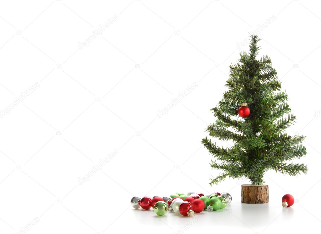 Small artificial tree with ornaments on white