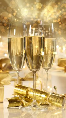 Glasses of champagne and gifts for new years clipart