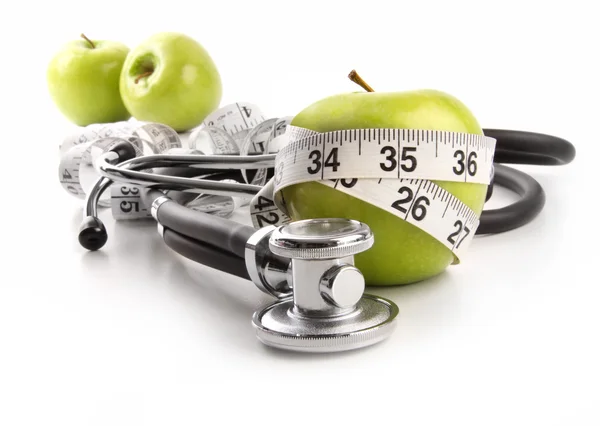 Green apples with stethoscope against white — Stock Photo, Image