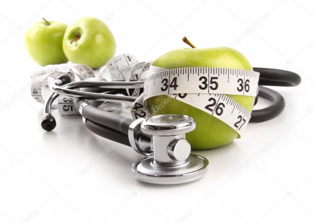 Green apples with stethoscope against white