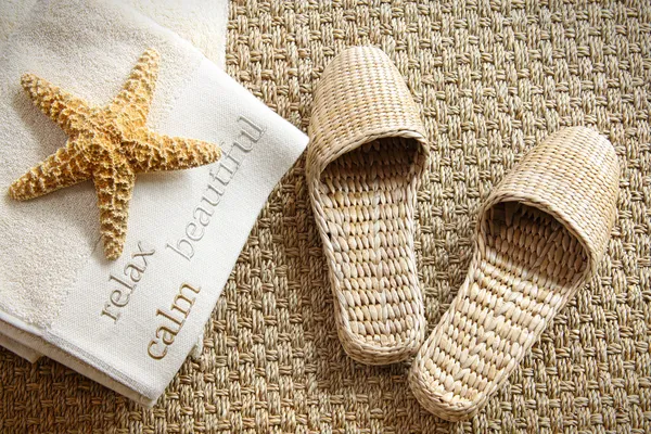 Spa kapcie na dywan trawa morska z ręcznikami — Zdjęcie stockowe