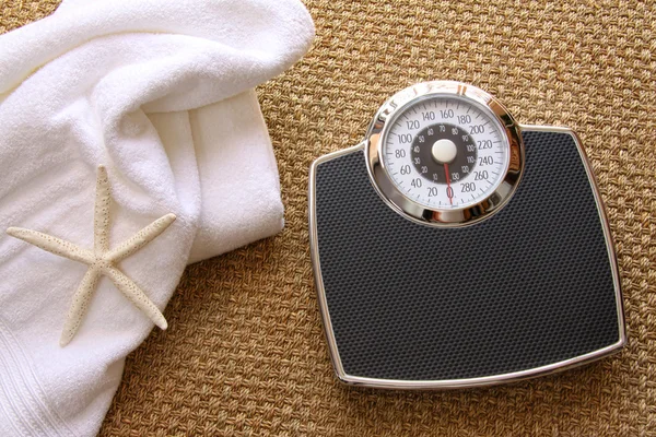Balança de peso com toalha no tapete — Fotografia de Stock