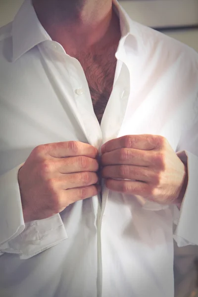Groom buttons his shirt before the wedding — Stock Photo, Image
