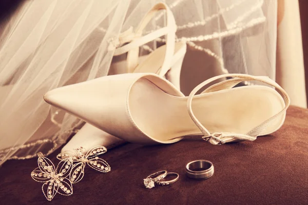 Wedding shoes with veil and rings on velvet chair — Stock Photo, Image