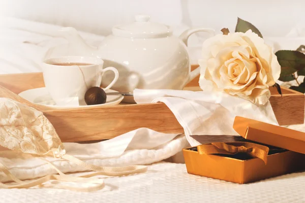 Yatakta çay ve çikolata ile rahatlatıcı — Stok fotoğraf