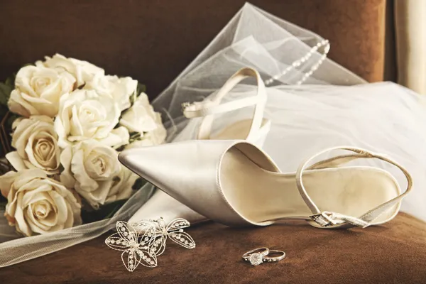 Bröllop skor med bukett vita rosor och ring Stockbild