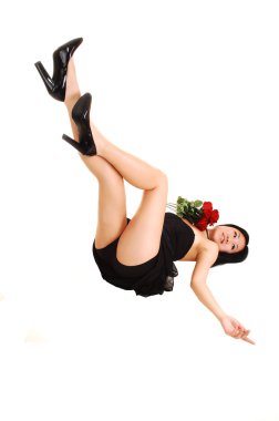 A young Asian woman in a black dress and panties lying on the floor in the studio and looking in the camera, for white background. clipart