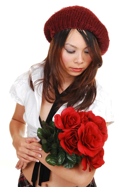 跪在工作室里黑色的短裙和高跟鞋 带着一束红玫瑰在她的怀里 为白色背景的年轻美貌的亚洲女孩 — 图库照片
