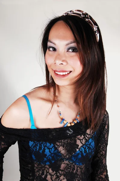 一名年轻的亚裔女子长棕色头发的肖像蓝色的胸罩和蕾丝黑色上衣 头带面带笑容的浅灰色的背景上 — 图库照片