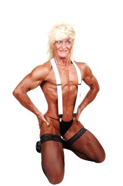 A blond muscular bodybuilding woman kneeling in the studio shooing her strong legs and the upper body and arms, with white suspender, over white background. clipart