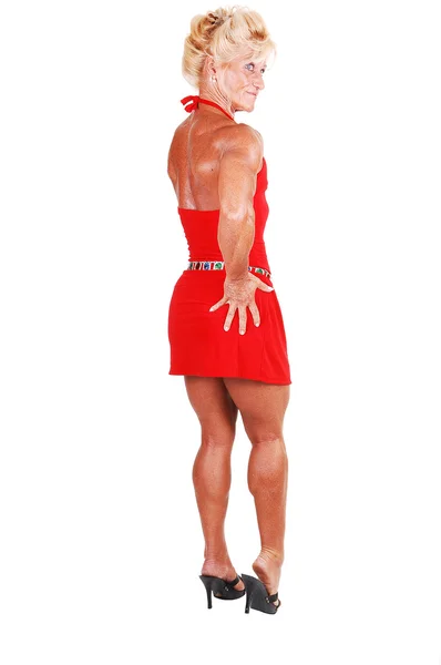 Μια Ξανθιά Bodybuilding Κορίτσι Στέκεται Ένα Στούντιο Ένα Κόκκινο Φόρεμα — Φωτογραφία Αρχείου