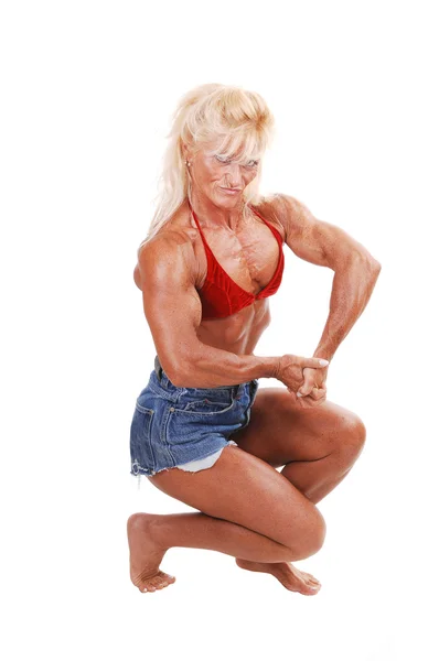 Uma Menina Musculosa Loira Ajoelhada Estúdio Atirando Suas Pernas Fortes — Fotografia de Stock