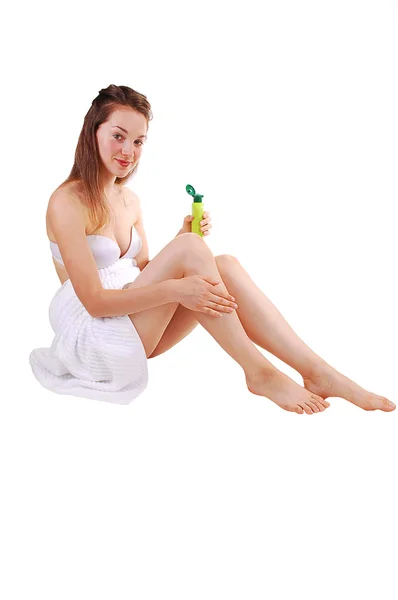 白い背景のための足に彼女の肌の世話をして タオルでラップ シャワーのあと床に座って 若いきれいな女の子 — ストック写真