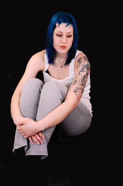 çok üzgün mavi saçlı genç kız ve büyük bir dövme Sol kolunda arıyorsunuz, siyah zemin katta oturan,