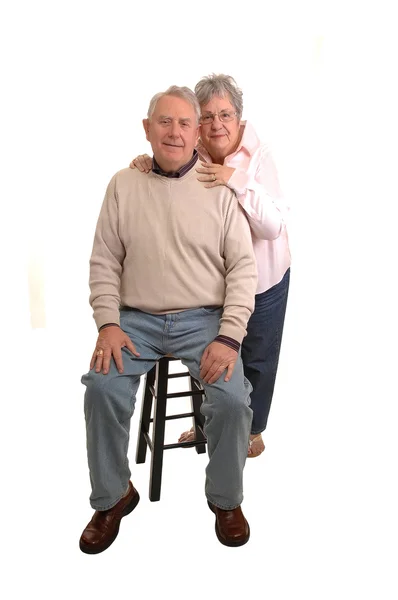 高齢者のカップルは 彼は座っていると彼女は肖像画のための後ろに立っているショット 白背景用 — ストック写真