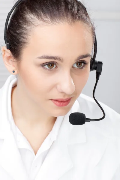 Kvinna med headsetet över vit bakgrund — Stockfoto