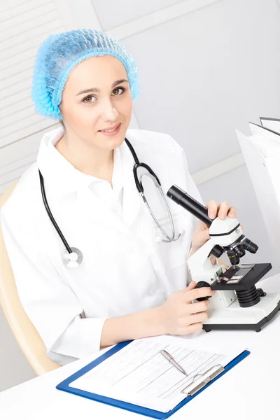 医疗-女护士在显微镜看 — 图库照片