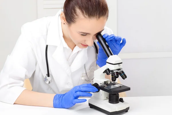 Ιατρική - θηλυκό νοσοκόμα ψάχνει στο μικροσκόπιο — Φωτογραφία Αρχείου