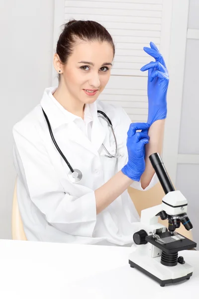 Medisch - vrouwelijke verpleegster op zoek in Microscoop — Stockfoto