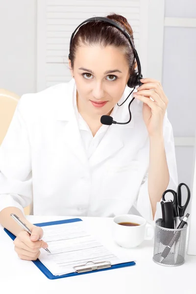 Wanita dengan headset di atas latar belakang putih — Stok Foto