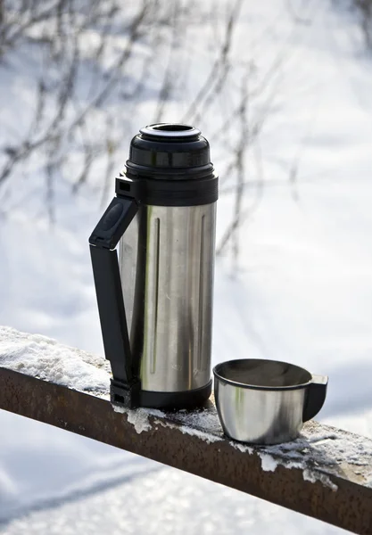 stock image Metal thermos with hot tea drink. Winter.