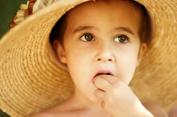 Little boy in straw hat eats — Stock Photo, Image
