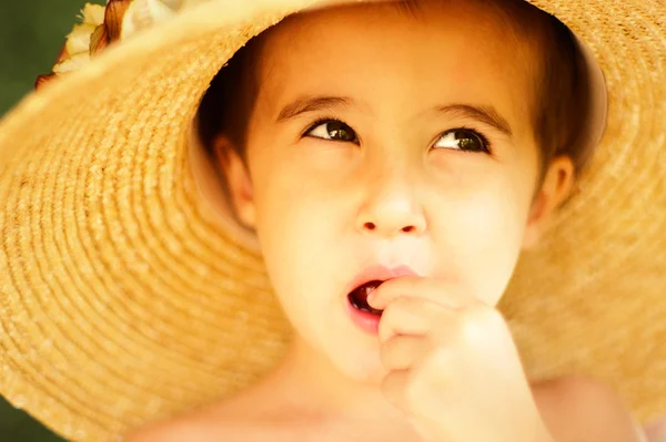 Naughty little boy in straw hat eats — Stock Photo, Image