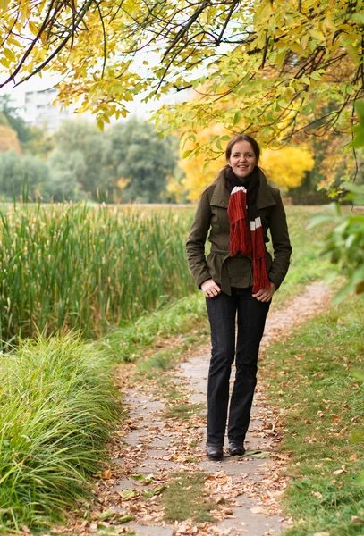 Rödhårig kvinna promenader i parken — Stockfoto