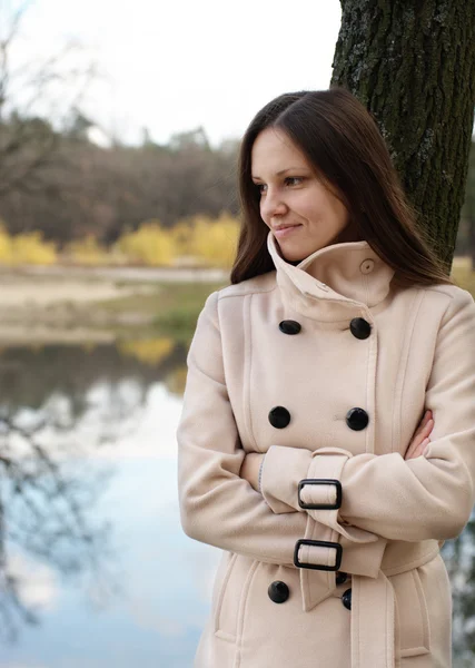 Mujer joven junto al lago de otoño — Foto de Stock