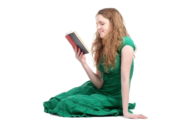 Руда жінка в зеленій сукні читає книгу — стокове фото
