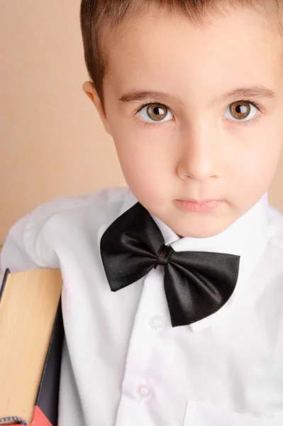 领结与书里的小书呆子男孩。 — 图库照片