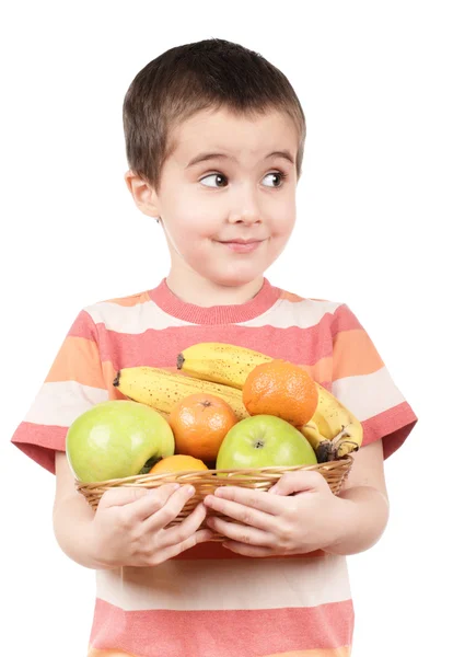 Liten pojke håller äpplen, mandariner och banan — Stockfoto